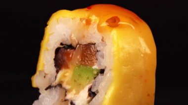 Suşiye tatlı ve ekşi sos dökülür. Geleneksel Japon yemekleri..