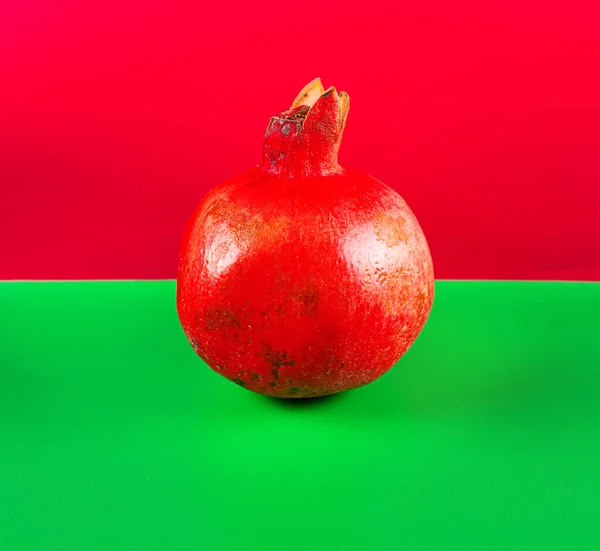 赤と緑の背景にザクロ — ストック写真