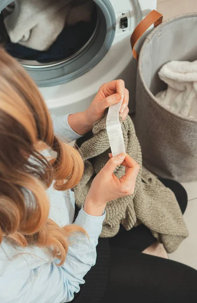 Mulher Olhando Para Etiqueta Roupa Antes Carregar Roupas Máquina Lavar — Fotografia de Stock