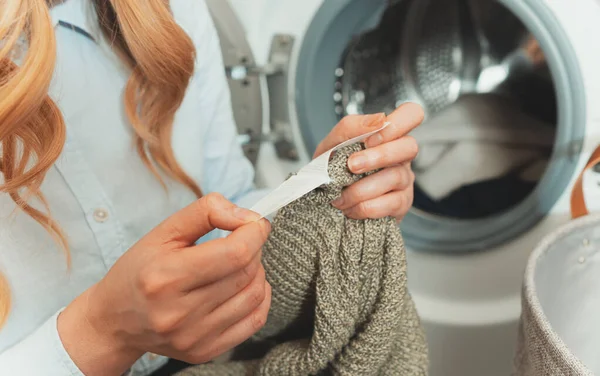 Mulher Olhando Para Etiqueta Roupa Antes Carregar Roupas Máquina Lavar — Fotografia de Stock