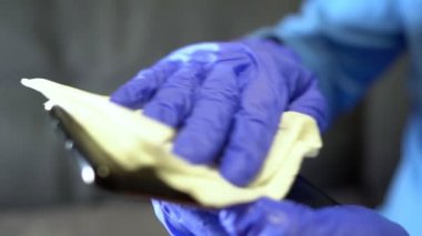 Koruyucu eldiven ve peçete temizleme cep telefonu. Covid-19 dezenfeksiyon konsepti.