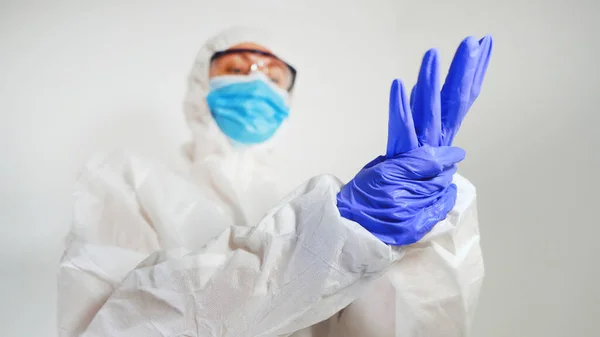 Mediziner Schutzanzug Zieht Handschuhe — Stockfoto