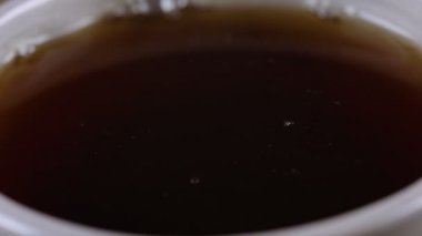 Fincana düşen taze demlenmiş çay damlası. Yavaş çekim videosu.