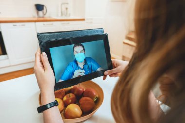 Kadın doktoruyla görüntülü konuşma yapıyor..