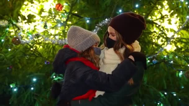 妈妈和女儿戴着防护面具站在圣诞树旁 — 图库视频影像