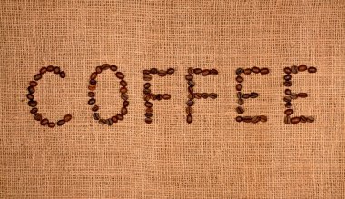 Harflerle hazırlanmış kavrulmuş kahve çekirdekleri. Çantanın üzerinde kahve..