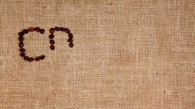 Harflerle hazırlanmış kavrulmuş kahve çekirdekleri. Çantanın üzerinde kahve..