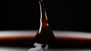 Beyaz fincana düşen kahve damlası. Yavaş çekim.