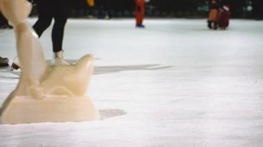 İnsanlar kışın buz pateni pistinde buz pateni yaparlar..