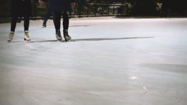 İnsanlar kışın buz pateni pistinde buz pateni yaparlar..