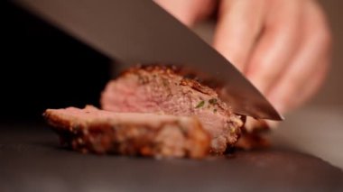 Kadın sulu ördek filetosunu bıçakla kesiyor..