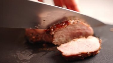 Kadın sulu ördek filetosunu bıçakla kesiyor..