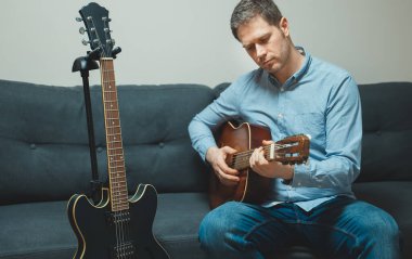 Evde İspanyol gitarı çalan yakışıklı adam..