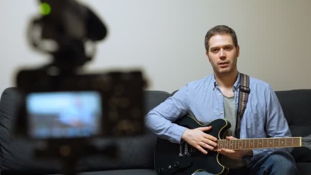 ビデオカメラの前で半音響ギターを持つ男 — ストック動画