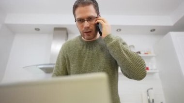 Cep telefonundan konuşan üzgün bir adam. Evden iş yapmak..