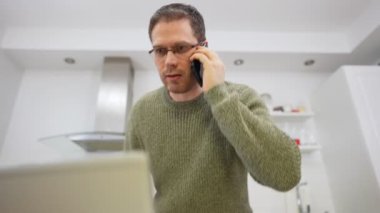 Cep telefonundan konuşan üzgün bir adam. Evden iş yapmak..