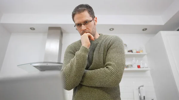 自己分離で台所のノートパソコンの近くの男 — ストック写真