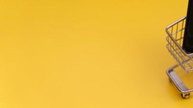 Akıllı telefonlu alışveriş arabası. Çevrimiçi alışveriş kavramı.