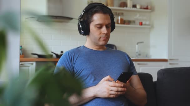 Άντρας Ακουστικά Που Ακούει Μουσική Στον Καναπέ — Αρχείο Βίντεο
