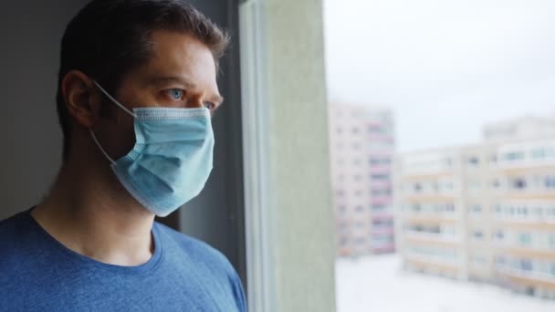 Tired Man Medical Mask Looks Out Window — Stock Video