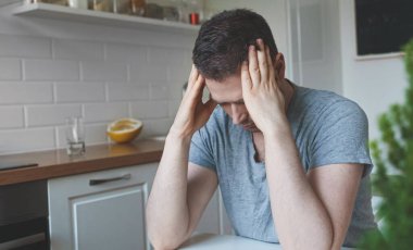 Mutfakta oturan yorgun adam..