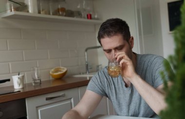 Sarhoş adam mutfakta viski içiyor..