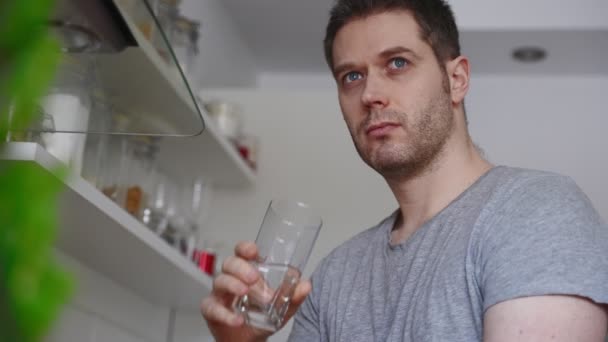 Ongeschoren Man Drinkt Water Uit Een Glas Keuken — Stockvideo