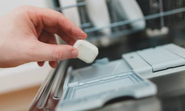 Bulaşık makinesine deterjan koyan adam..