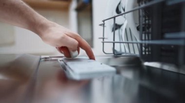 Bulaşık makinesine deterjan koyan adam..