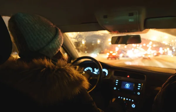 Woman driving a car in winter time.