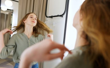 Giyim mağazasının soyunma odasında duran genç kız..