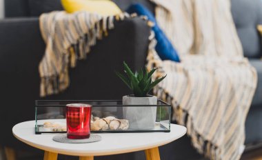 Battaniye ve yastıklı komodin ve kanepe..