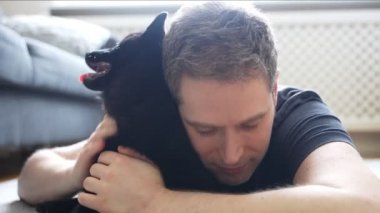 Adam yeni yavrusu Schipperke 'ye sarılıyor..
