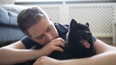Adam yeni yavrusu Schipperke 'ye sarılıyor..