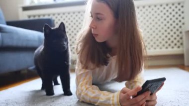 Akıllı telefon ve meraklı köpek yavrusu olan genç bir kız..
