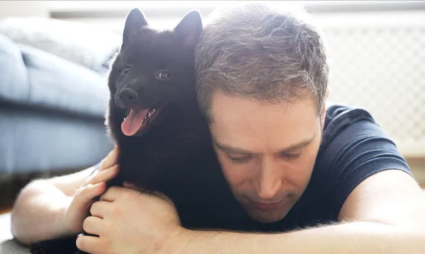 Man Hugs His New Puppy Schipperke — Stock Photo, Image