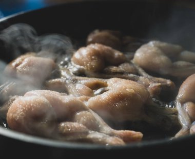 Geleneksel tavada kızarmış kurbağa bacağı pişirme.