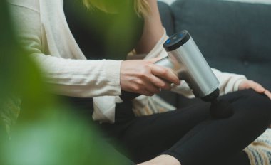 Evde masaj aletli masaj yapan bir kadın..