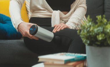 Evde masaj aletli masaj yapan bir kadın..