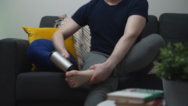 Мужчина Массирует Ноги Помощью Массажного Перкуссионного Устройства Дома — стоковое видео