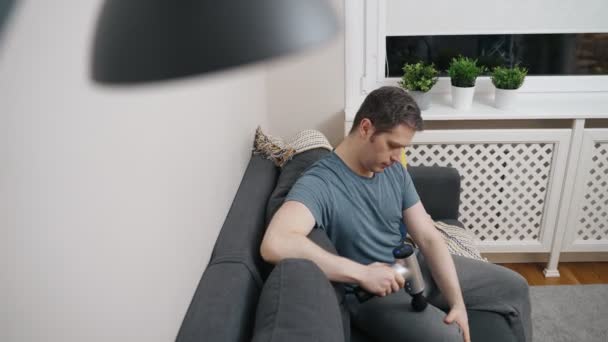 Мужчина Массирует Ногу Помощью Массажного Ударного Устройства Дома — стоковое видео