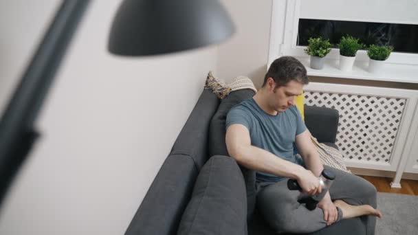 男マッサージ脚とともにマッサージパーカッション装置とともに自宅 — ストック動画