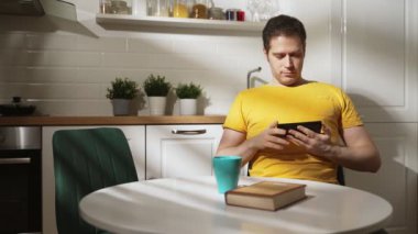 Adam çay içiyor ve akıllı telefon kullanıyor..