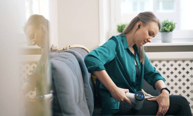 Evde masaj aletli masaj yapan bir kadın..