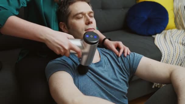 Donna Massaggiante Uomo Con Dispositivo Massaggio Percussione Casa — Video Stock