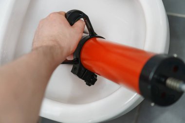 Profesyonel güç pompası temizleyicisiyle tıkanan tuvaleti açıyorum..