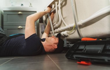Adam banyo küvetinin boru sistemini hidromasaj ile kuruyor..