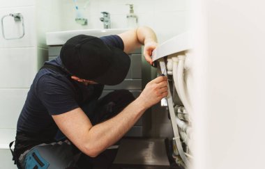 Adam banyo küvetinin boru sistemini hidromasaj ile kuruyor..