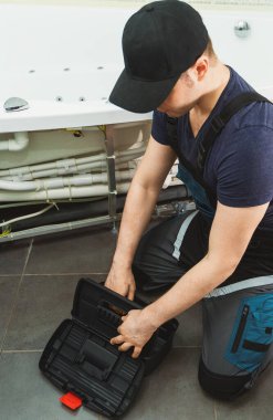 Adam banyo küvetinin boru sistemini hidromasaj ile kuruyor..