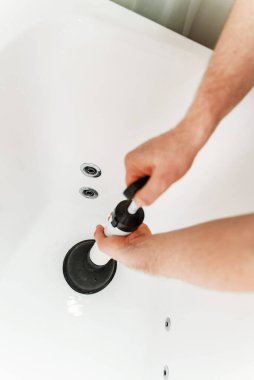 Su tesisatçısı profesyonel güç pompasıyla küveti boşaltıyor..